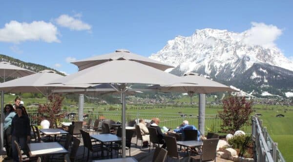 Grey Shade7 Paraflex wall-mounted sun umbrellas over an alpine terrace
