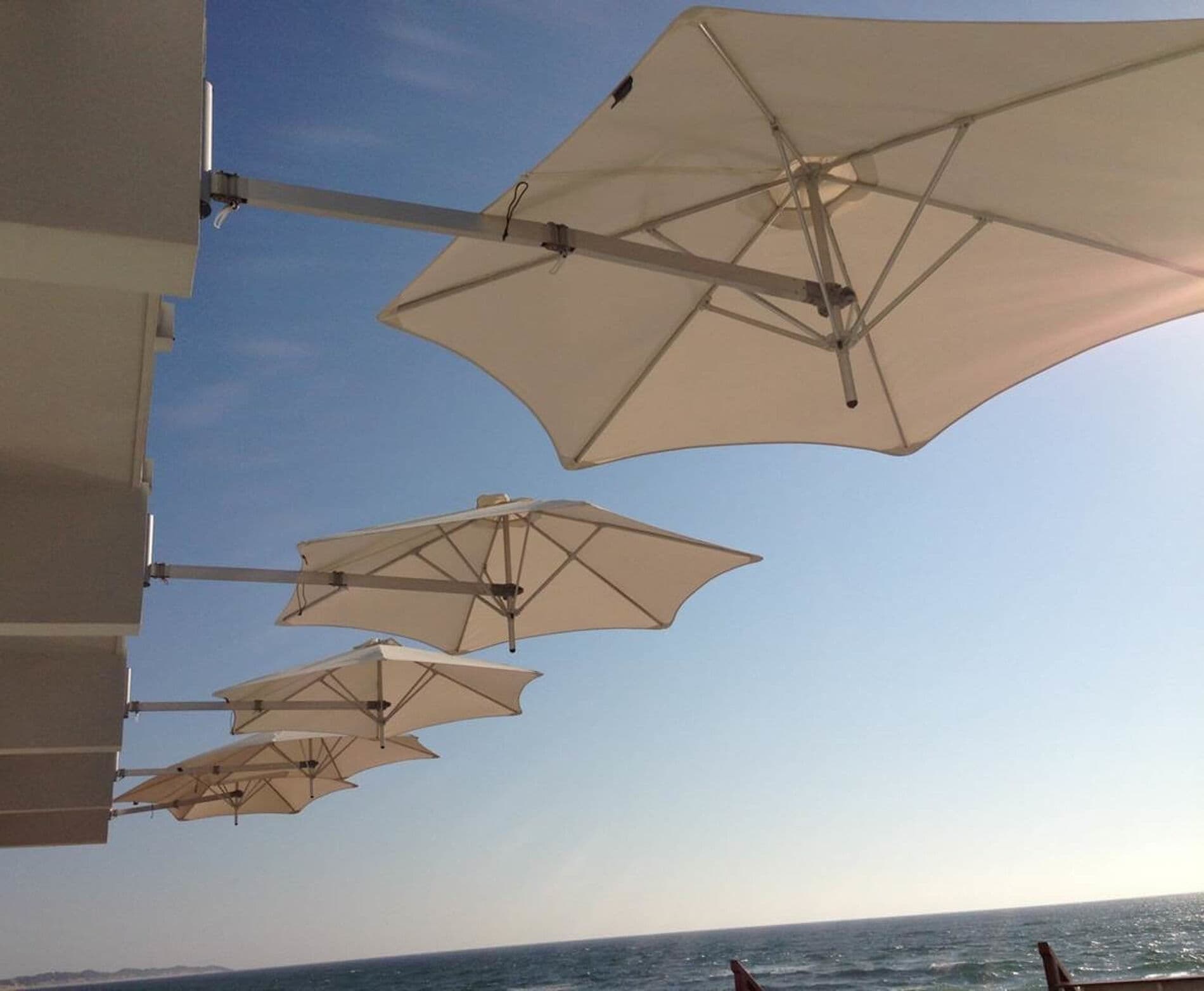 Shade7 Paraflex wall-mounted sun umbrellas over an outdoor dining area